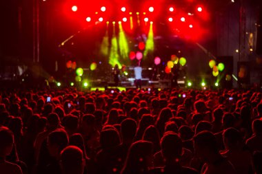 konserin siluetleri parlak sahne ışıkları önünde kalabalık. Mo