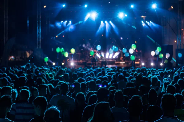 Silhuetas de multidão de concerto na frente de luzes de palco brilhantes. mo — Fotografia de Stock