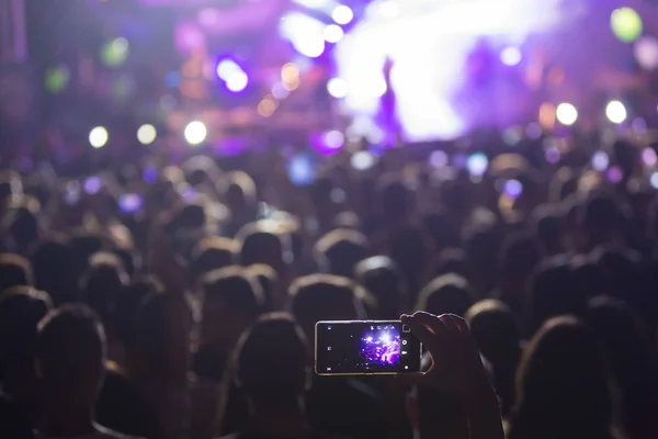 Mão com um smartphone grava festival de música ao vivo — Fotografia de Stock