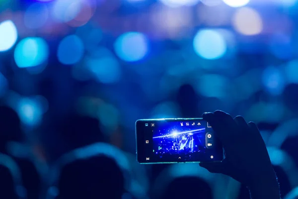 Мбаппе со смартфоном записывает фестиваль живой музыки — стоковое фото