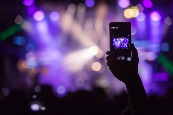 Mão com um smartphone grava festival de música ao vivo — Fotografia de Stock