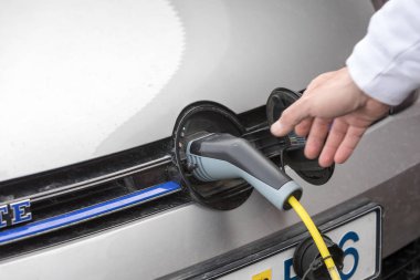 Elektrik kablosu prize takılı bir elektrikli arabayı şarj etmek...