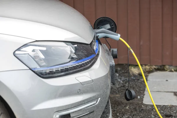 Ładowanie elektrycznego samochodu z podłączonym kablem zasilającym — Zdjęcie stockowe