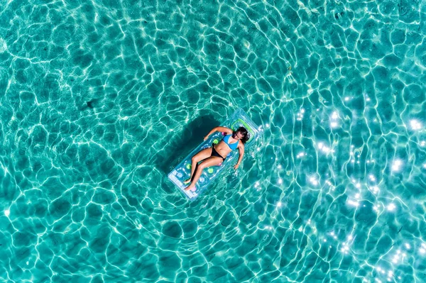 Vista aérea de uma bela jovem mulher de biquíni em um colchão i — Fotografia de Stock