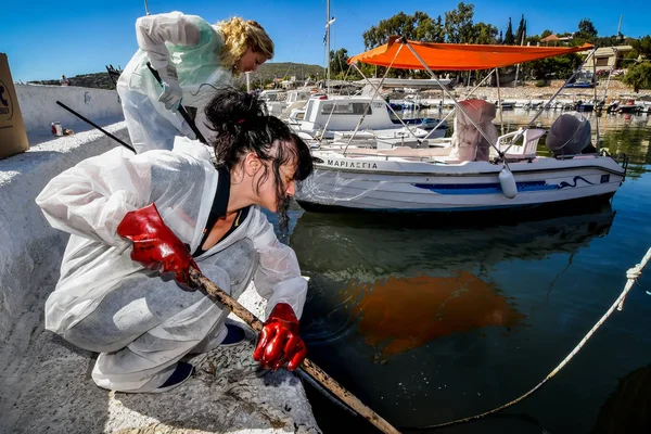 Workers try to clean up oil that has washed ashore, on a beach o — Stock Photo, Image