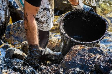 İşçiler karaya, bir plaj o yıkadı petrol temizlemek deneyin