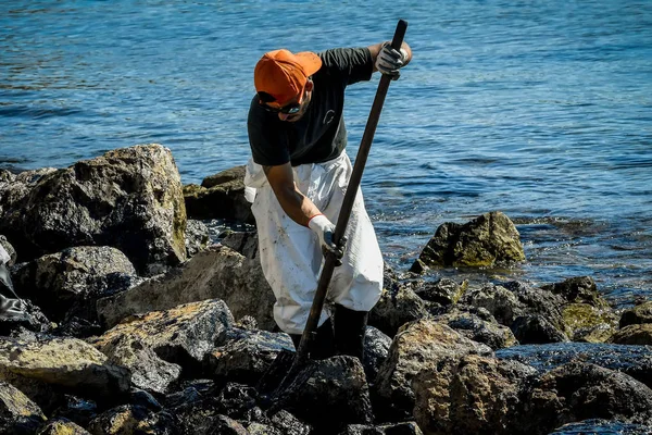 Εργαζόμενοι προσπαθήστε να καθαρίσετε επάνω το πετρέλαιο που έχει πλυθεί στην ξηρά, σε μια παραλία o — Φωτογραφία Αρχείου