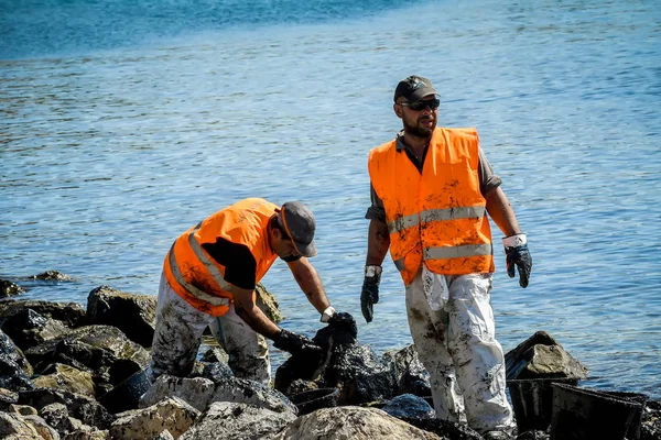 İşçiler karaya, bir plaj o yıkadı petrol temizlemek deneyin