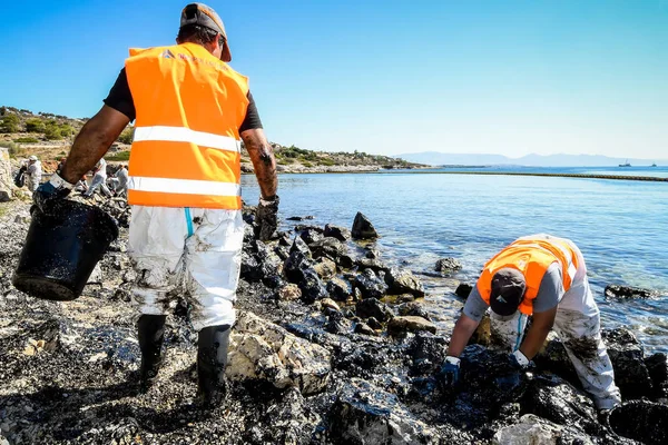 Εργαζόμενοι προσπαθήστε να καθαρίσετε επάνω το πετρέλαιο που έχει πλυθεί στην ξηρά, σε μια παραλία o — Φωτογραφία Αρχείου