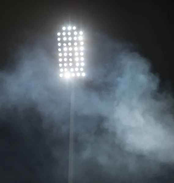 Luci dello stadio e fumo contro buio notte cielo sfondo — Foto Stock