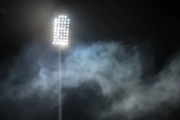 Luci dello stadio e fumo contro buio notte cielo sfondo — Foto Stock