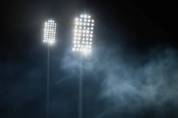 体育场灯光和烟在黑暗的夜空背景 — 图库照片