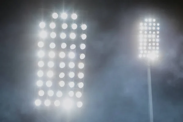 Luces del estadio y humo contra el fondo oscuro del cielo nocturno — Foto de Stock