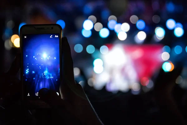 Hand with a smartphone records live music festival — Stock Photo, Image