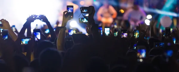 Hand with a smartphone records live music festival — Stock Photo, Image