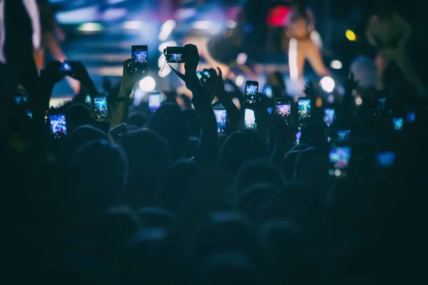 Hand with a smartphone records live music festival — Stock Photo, Image