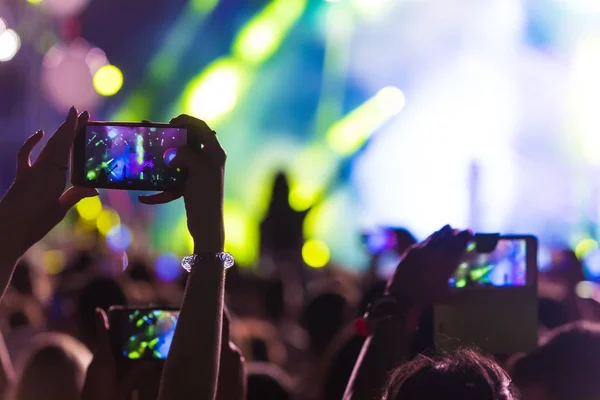 Hand mit Smartphone nimmt Live-Musik-Festival auf — Stockfoto