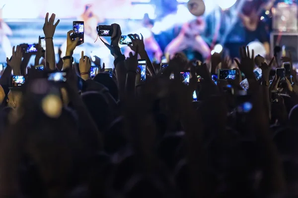 Hand met een smartphone records live muziekfestival — Stockfoto