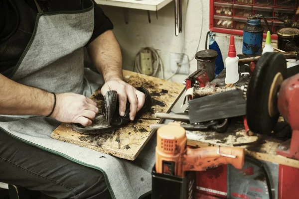 Обувщик ремонтирует подошву для обуви в мастерской — стоковое фото