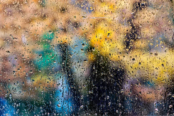 Regentropfen auf ein Fenster. Wald im Hintergrund verwischen. — Stockfoto