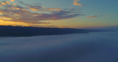 Havadan görünümü. Bulutların üzerinde uçan. Hava kamera çekim. Gün batımı sırasında. Manzara panorama.