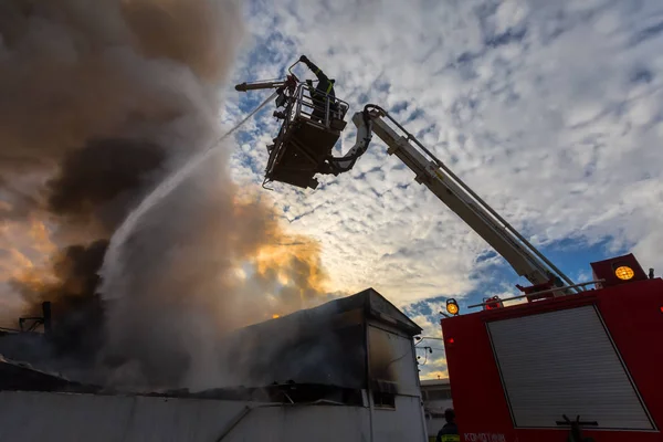 Feuerwehrleute tun sich schwer, das Feuer zu löschen, das in dem Haus ausbrach. — Stockfoto