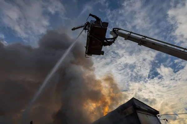 Feuerwehrleute tun sich schwer, das Feuer zu löschen, das in dem Haus ausbrach. — Stockfoto