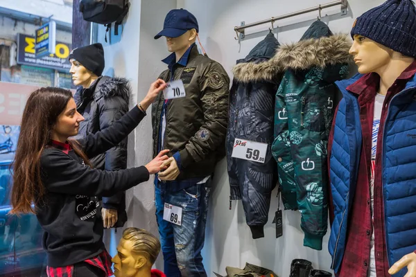 女性が冬割引の観点からテッサロニキの中心の衣料品店でウィンドウのショーケースを飾るテッサロニキ ギリシャ 2018 — ストック写真