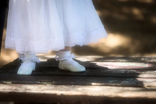 Kinderfüße in Schuhen auf dunklem Holz — Stockfoto