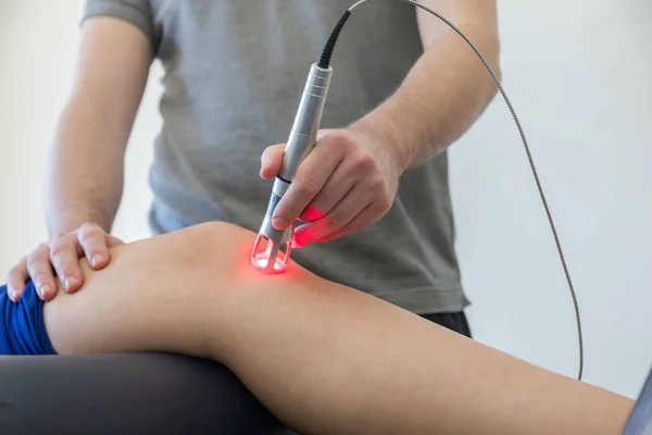 Laser therapy on a knee used to treat pain. selective focus — Stock Photo, Image