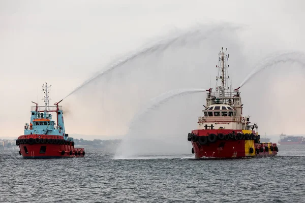 Fire ships throws water during extinguishes a fire on in an exer — Stock Photo, Image