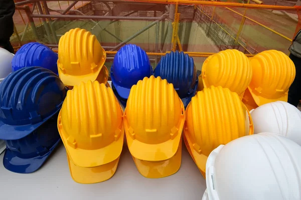 Сині, жовті та білі шоломи на будівельному майданчику — стокове фото