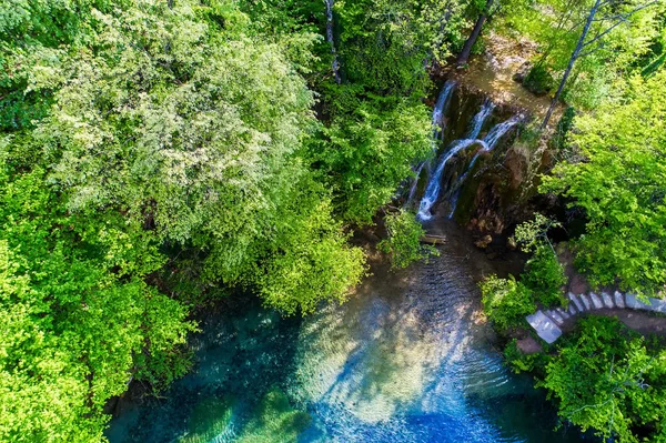 Beautiful waterfall and a small lake with green waters in Skra a — Stock Photo, Image