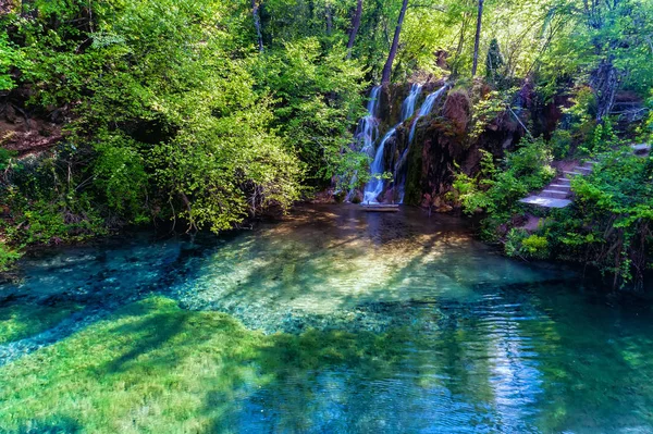 Bella cascata e un piccolo lago con acque verdi a Skra a — Foto Stock