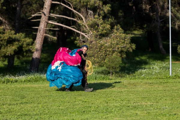 Ember egy siklóernyővel integetett leszállás után zöld mezőn — Stock Fotó