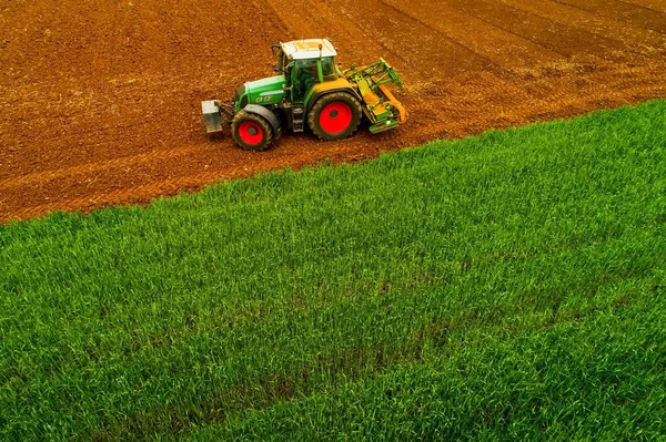 Tiro aéreo de agricultor com um trator no campo agrícola — Fotografia de Stock