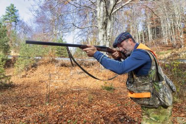 Ormanda silah kovalayan bir avcı.