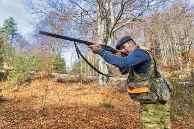 Ormanda silah kovalayan bir avcı.