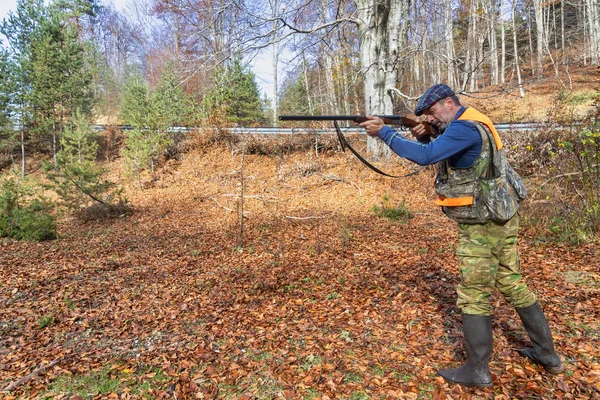 hunter with weapon chasing in the forest