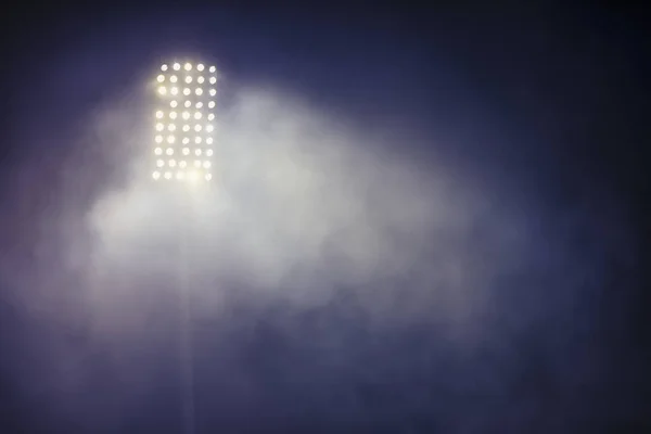 Stadium lights and smoke against dark night sky background — Stock Photo, Image