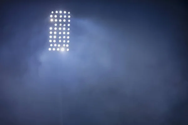 Stadion ljus och rök mot mörk natthimmel bakgrund — Stockfoto