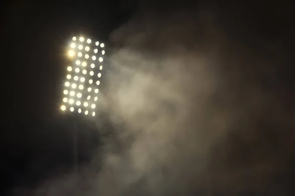 Stadionbeleuchtung und Rauch vor dunklem Nachthimmel — Stockfoto