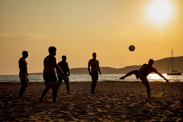 Ένα παιχνίδι του ποδοσφαίρου στην παραλία το ηλιοβασίλεμα — Φωτογραφία Αρχείου