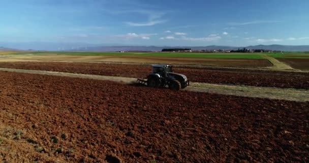 一名农民在拖拉机播种过程中遭到空中无人驾驶飞机射击 他在田里播种农作物 拖拉机在地里犁耕播种的拖拉机 — 图库视频影像