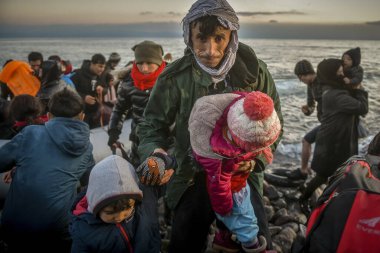 Lesbos, Greece, March 2, 2020: Refugees and Migrants aboard reach the Greek Island of Lesbos after crossing on a dinghy the Aegean sea from Turkey clipart