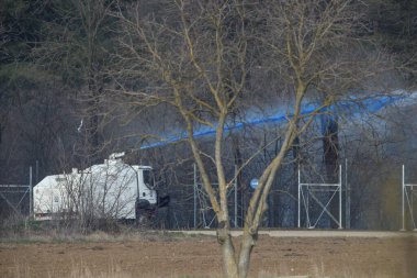 Kastanies, Evros, Greece - March 1, 2020: Greek police vehicle pours paint on migrants as they attempt to enter Greece from Turkey at the Greek-Turkish border in Kastanies