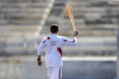 Atina, Yunanistan - 19 Mart 2020: Tokyo 2020 Yaz Olimpiyatları için Olimpiyat Alev devir töreni. Yunan Olimpiyat madalyası sahibi E. Petrounias, Panathenaic Stadyumu 'nda Tokyo Olimpiyat Alevi' ni düzenledi.