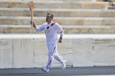 Atina, Yunanistan - 19 Mart 2020: Tokyo 2020 Yaz Olimpiyatları için Olimpiyat Alev devir töreni. Yunan Olimpiyat madalyası sahibi E. Petrounias, Panathenaic Stadyumu 'nda Tokyo Olimpiyat Alevi' ni düzenledi.