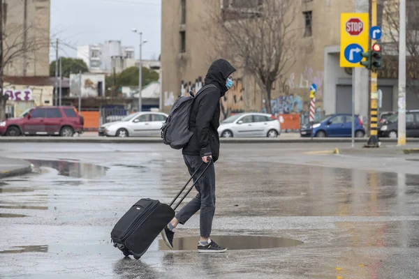 希腊塞萨洛尼基 2020年3月23日 一名戴着医疗面罩的妇女在空旷的路上行走 在塞萨洛尼基医院被政府强制关闭时拖着行李 以防止考罗纳威斯病毒的进一步蔓延 — 图库照片