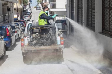 Selanik, Yunanistan - 8 Nisan 2020: İşçiler COVID-19 adlı romanın sokaklara ve meydanlara yayılmasına karşı önleyici tedbirler kapsamında dezenfektan sıktılar